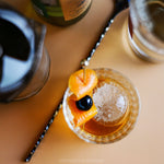 Cocktail with a fruit garnish on a bar surface, featuring Pressice Barware.